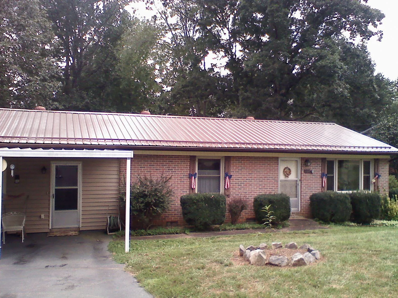 Bronze metal roof and carport on a brick ranch home — Roof Repair work by our crew in Musselshell